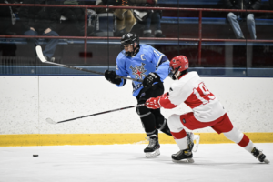 Max Tse pushes the puck along the boards.